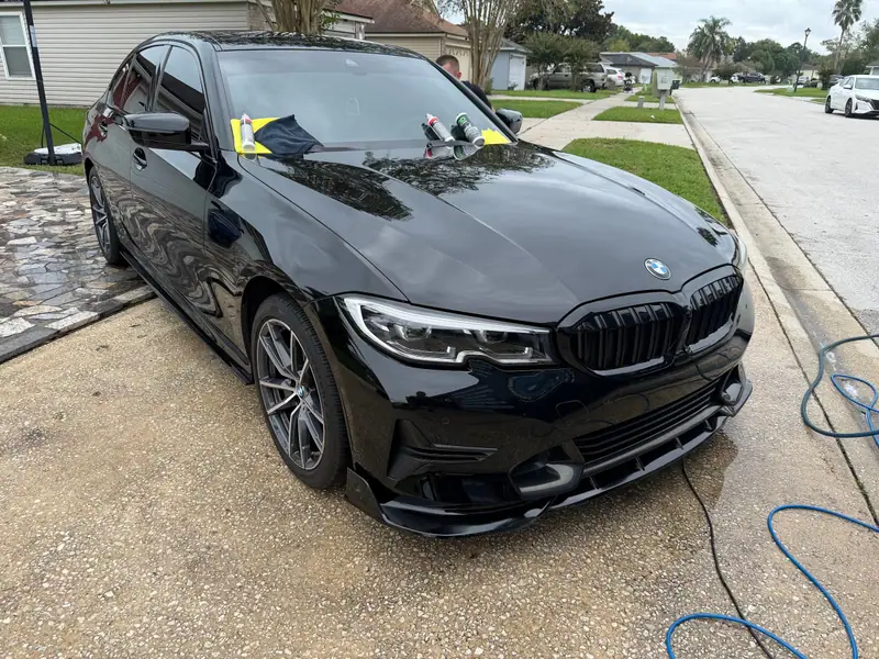 Black BMW 3 Series being detailed in a Jacksonville driveway on a mobile job