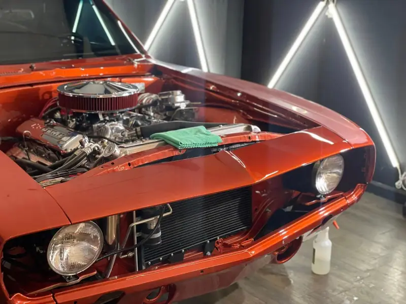 Classic orange muscle car engine bay cleaned and dressed by Maxx Perfection Detailing