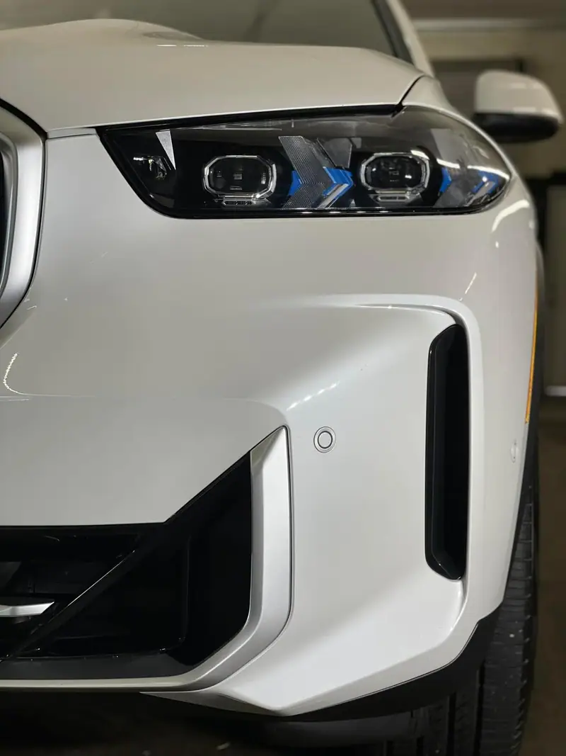 Crystal-clear headlight on a white car after a Maxx Perfection detail in Jacksonville