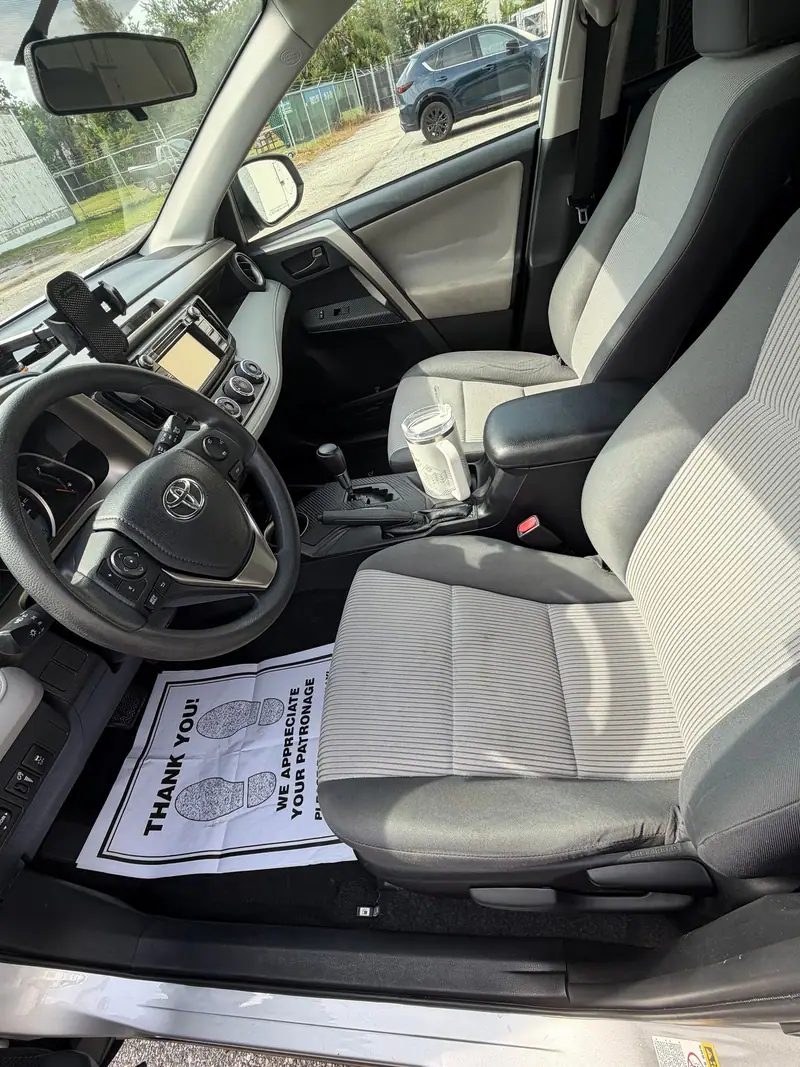 Clean front seats of a Toyota RAV4 after an interior detail, thank-you card on the floor mat