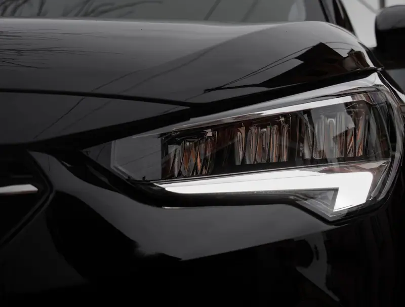 Clear LED headlight on a gloss-black car