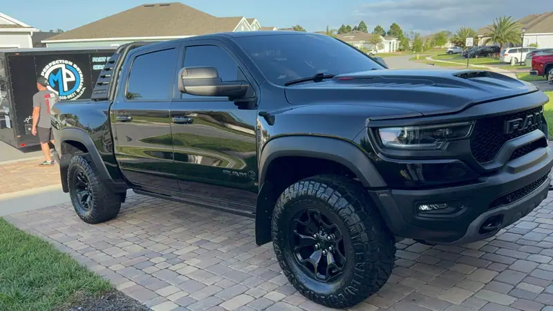 Ram TRX front end gleaming after ceramic coating, Maxx Perfection trailer parked beside it